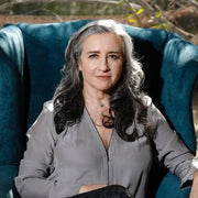 A woman with long hair sits in a chair, embodying a serene and healthy lifestyle, reflecting WeNatal's focus on prenatal wellness.